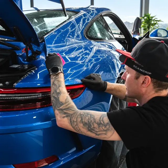 Aplikace ochranné PPF fólie na modré Porsche v dílně v Hradci Králové