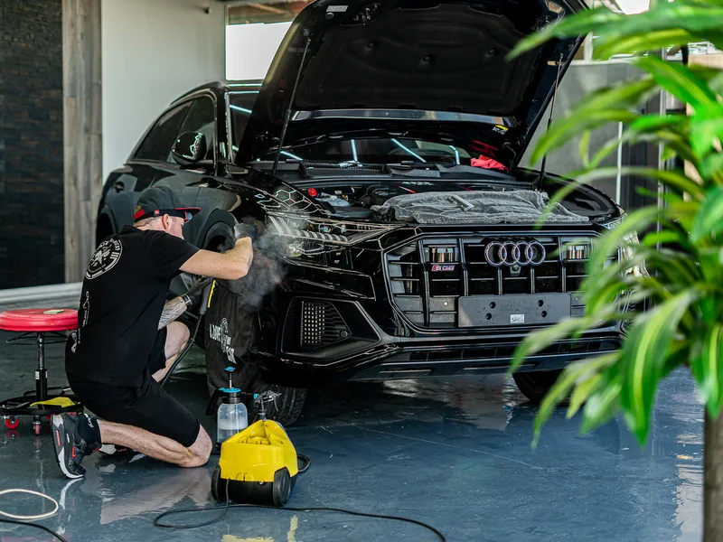 Tvarování PPF fólie parou na černém Audi v dílně