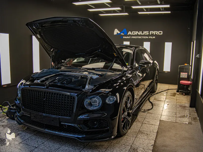 Černé Bentley s otevřenou kapotou ve studiu při aplikaci PPF fólie